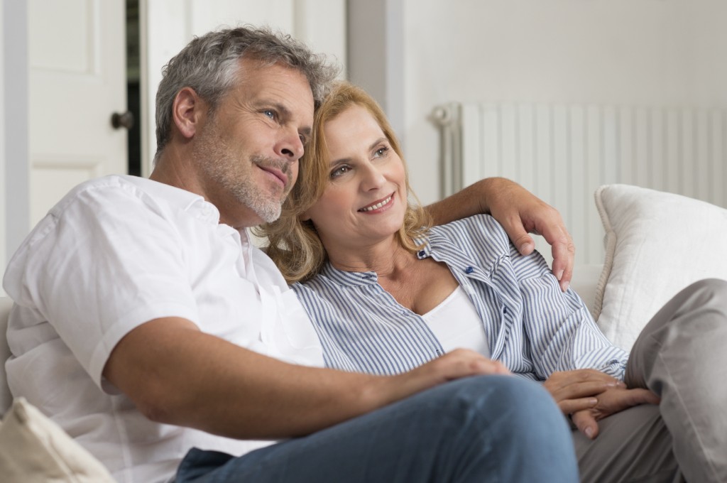 Mature Couple Sitting Together On Floor Stock Photo