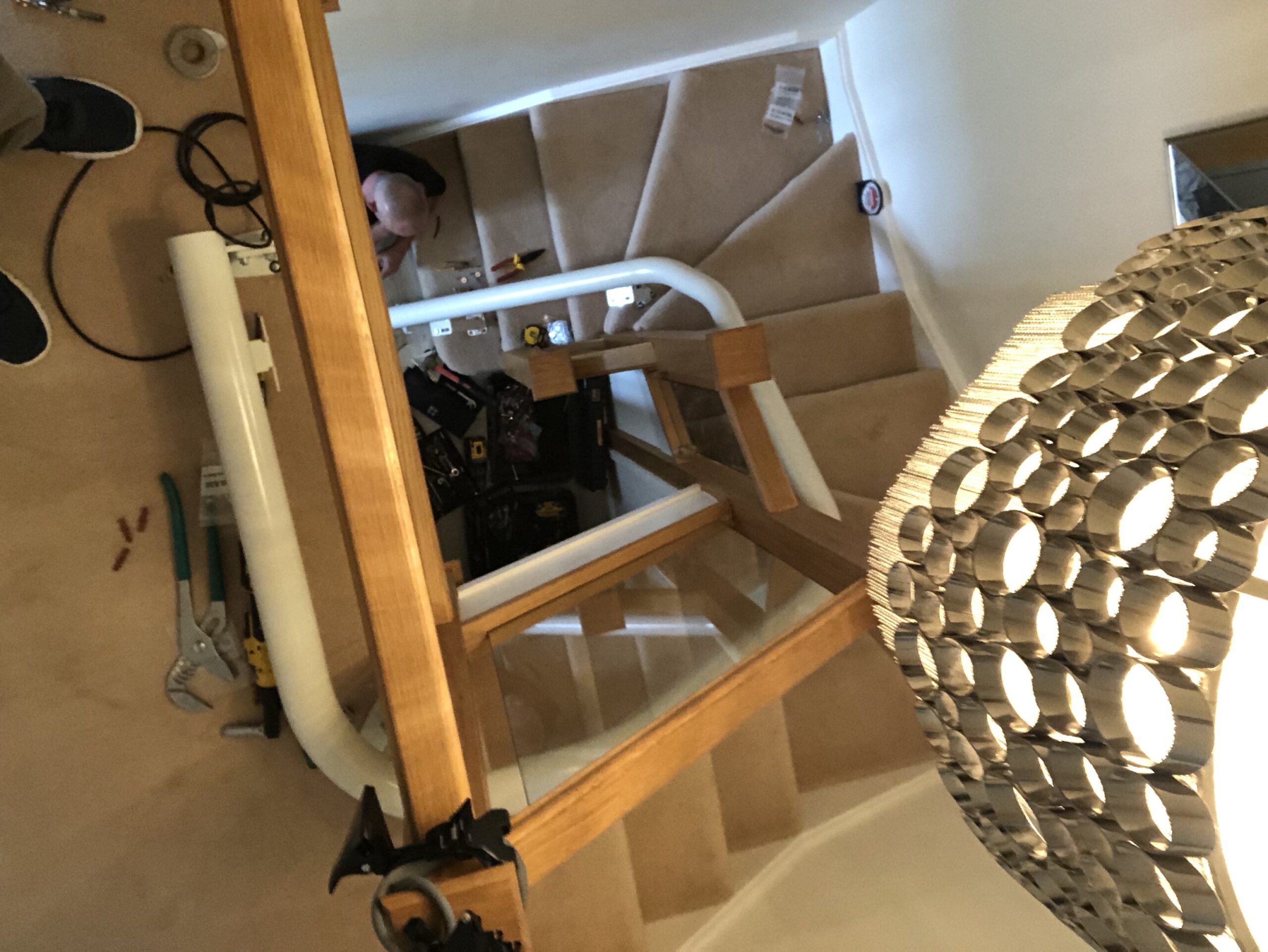 stairlift on a curved staircase with glass balustrade