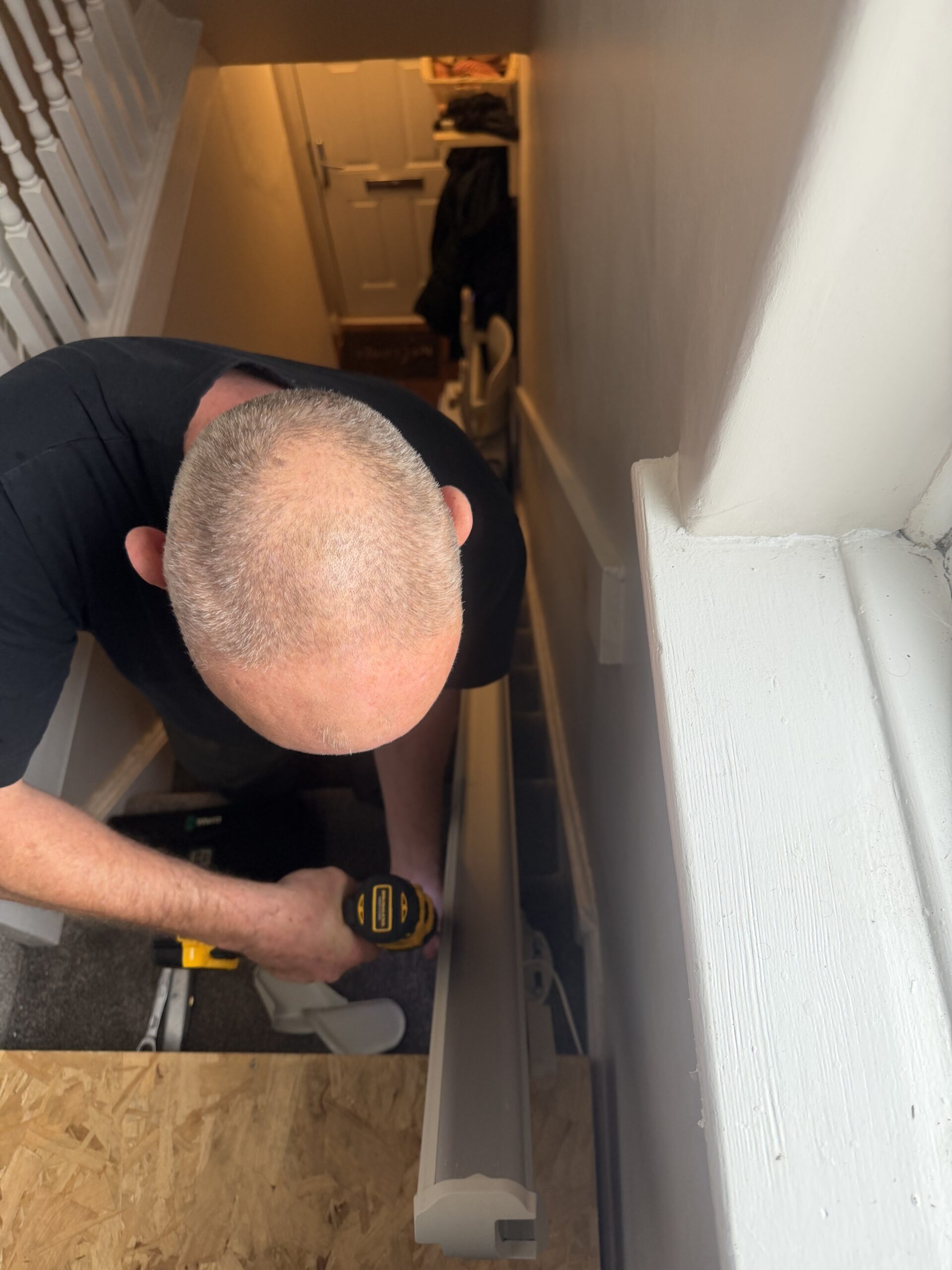 engineer unscrewing stairlift rail