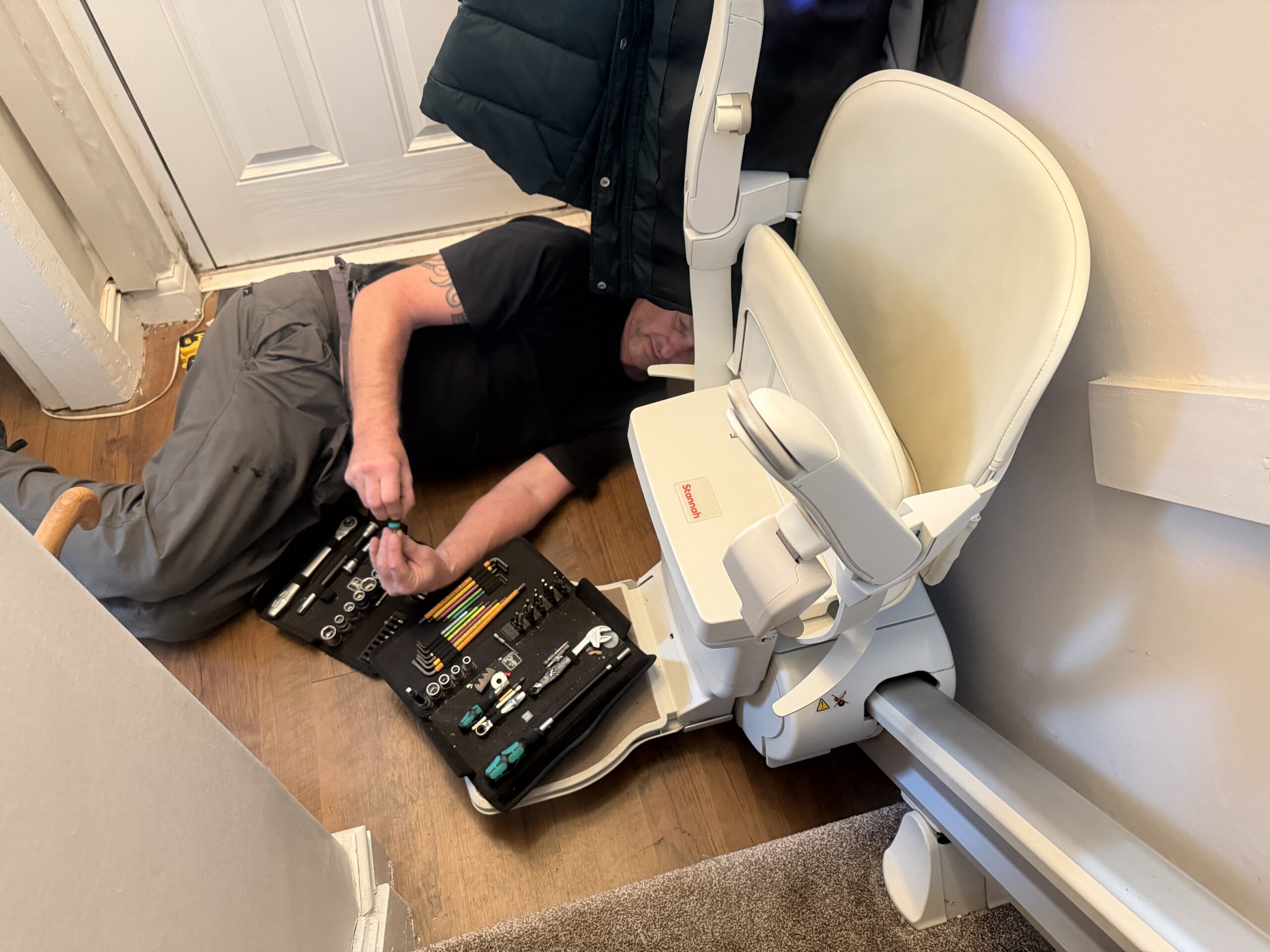 a stairlift engineer altering a stairlift
